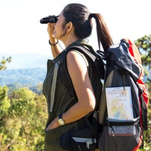 Frau bei Wanderung in der Natur schaut durch Accu Buddy